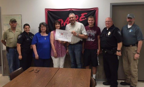 Image of eight people one of which is holding a sign that says, "Legend Love Police Officers".